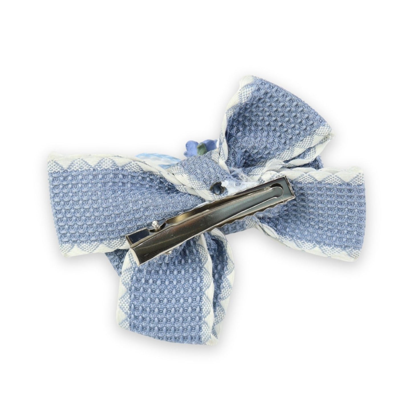 Close-up of the floral charm on the bow on the blue clip