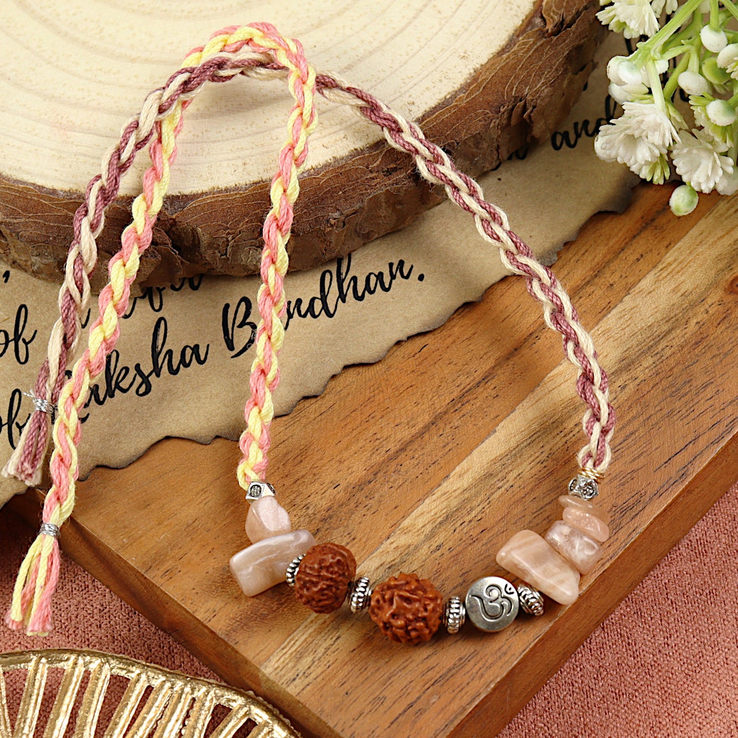 Sunstone Om Rudraksh Rakhi in sunstone, laid flat