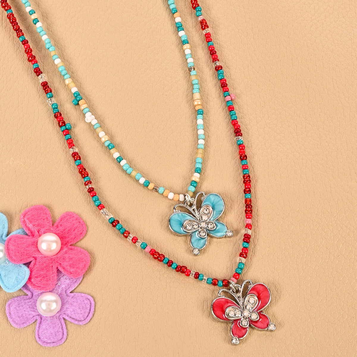 Set of 2 butterfly charm necklaces, laid flat