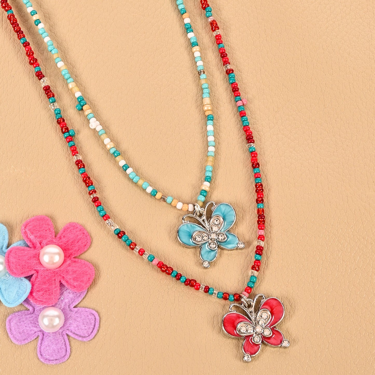 Set of 2 butterfly charm necklaces, laid flat