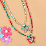 Set of 2 butterfly charm necklaces, laid flat