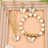 Butterfly Charm jewellery set for girls — necklace, bracelet, and earrings, laid flat