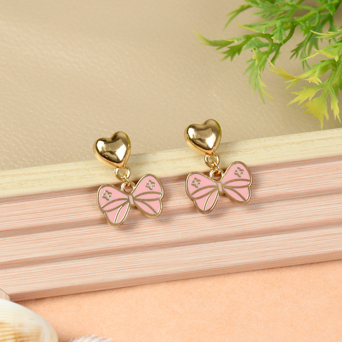Bow Charm earrings for girls in metal charms, laid flat