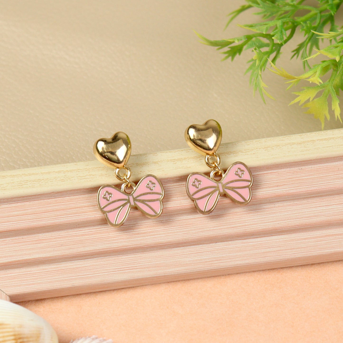 Bow Charm earrings for girls in metal charms, laid flat
