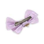 Close-up of the floral charm on the bow on the purple clip