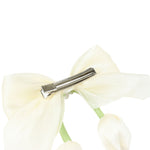Close-up of the floral charm on the bow on the white clip