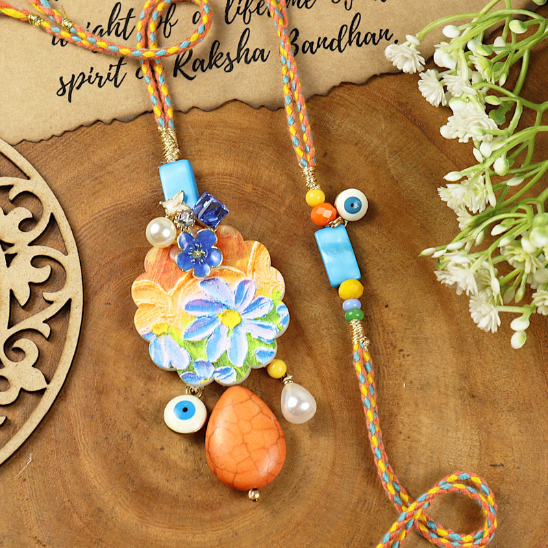 Floral Print Evil Eye Charm Bhai Bhabhi Rakhi pair — Rakhi and Lumba laid flat
