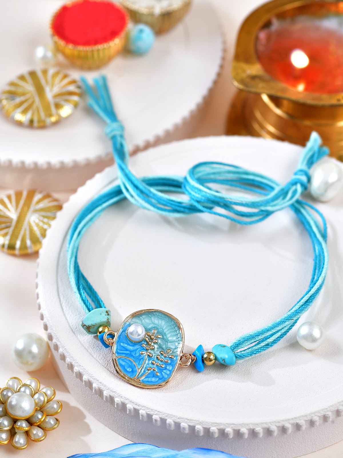 Floral stone Rakhi with floral stone motif on a thread cord