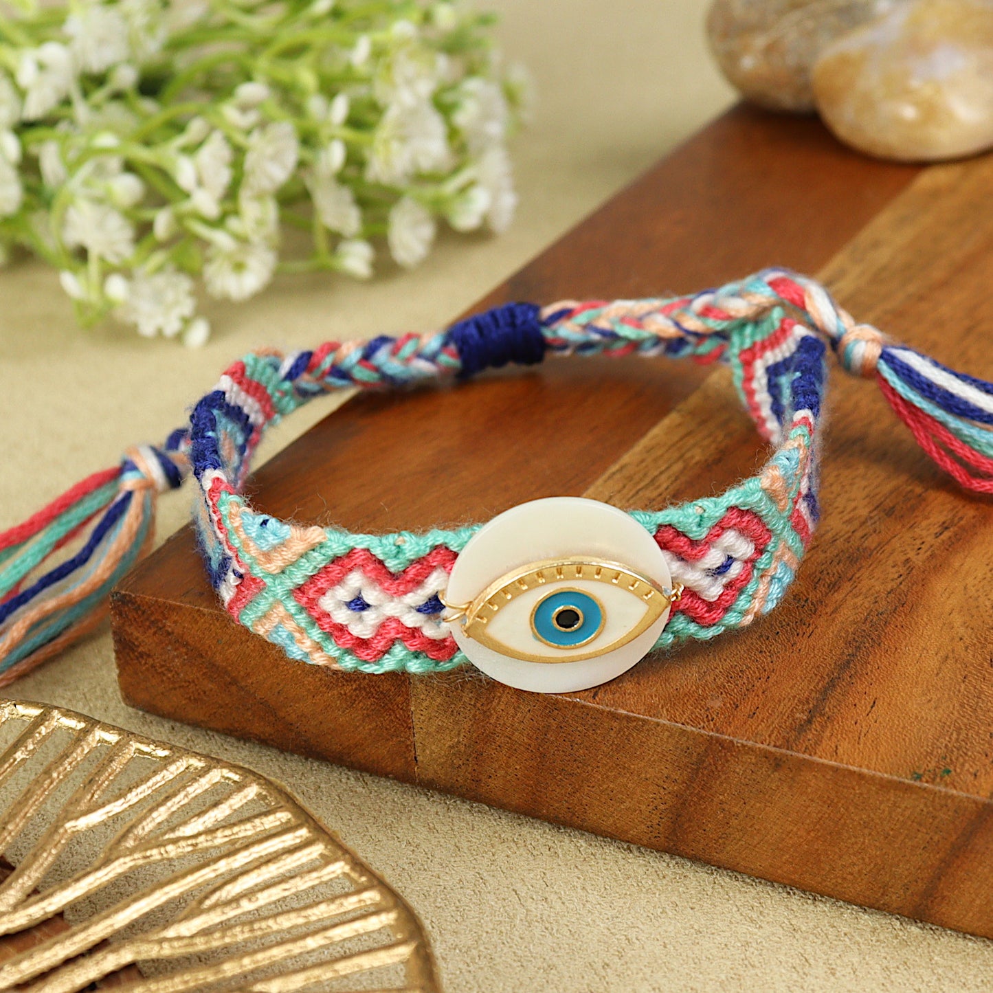 Handwoven Evil Eye Shell Bracelet Rakhi, laid flat