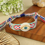 Handwoven Evil Eye Shell Bracelet Rakhi, laid flat