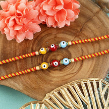 Load image into Gallery viewer, Set of of 2 Evil Eye Bead Fancy Thread Rakhis – Designer Rakhi by Asthetika for Raksha Bandhan
