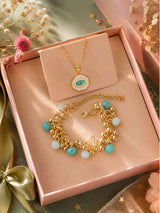 Pearls bracelet and evil eye enamel pendant set, laid flat
