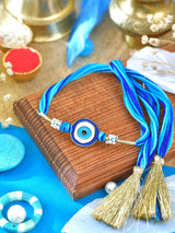 Evil Eye Stone Tassel Rakhi with Evil Eye charm and tassel on a thread cord