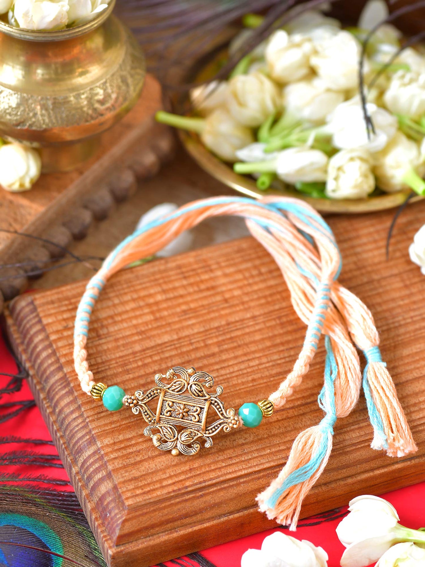 Carved stone Rakhi with carved stone detailing on a thread cord