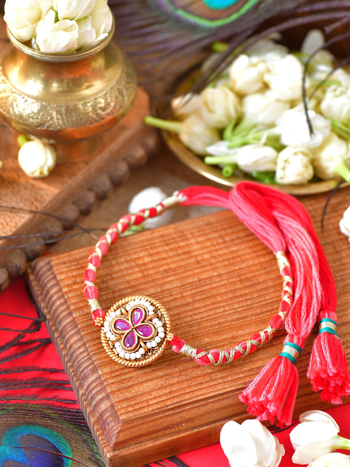 Ruby stone Rakhi with ruby stone setting on a thread cord