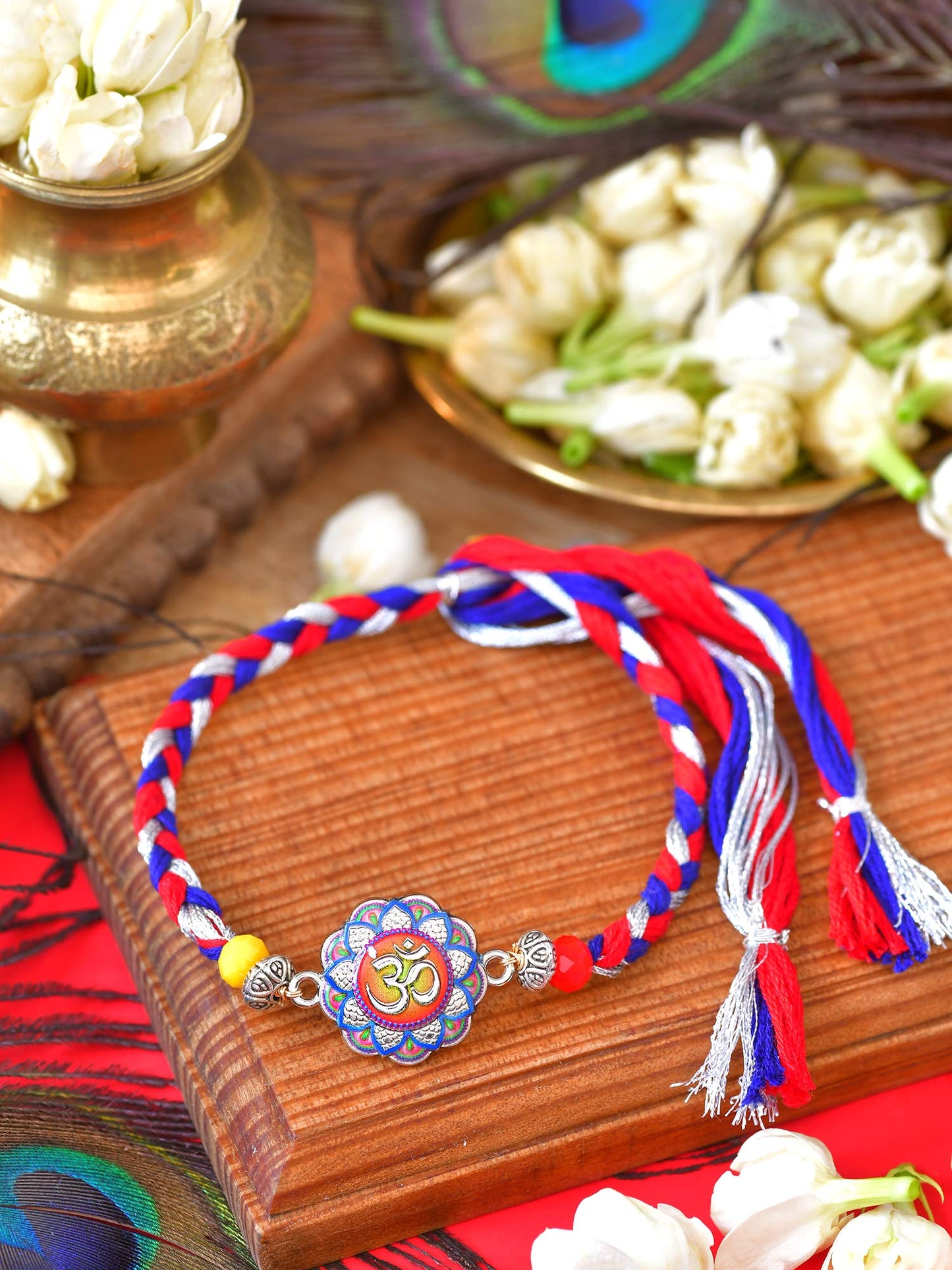 Om Minakari Rakhi with Om motif and Minakari stone finish on a thread cord