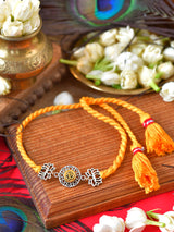 Om Lotus Tassel Rakhi with Om Lotus metal charm and tassel on a thread cord