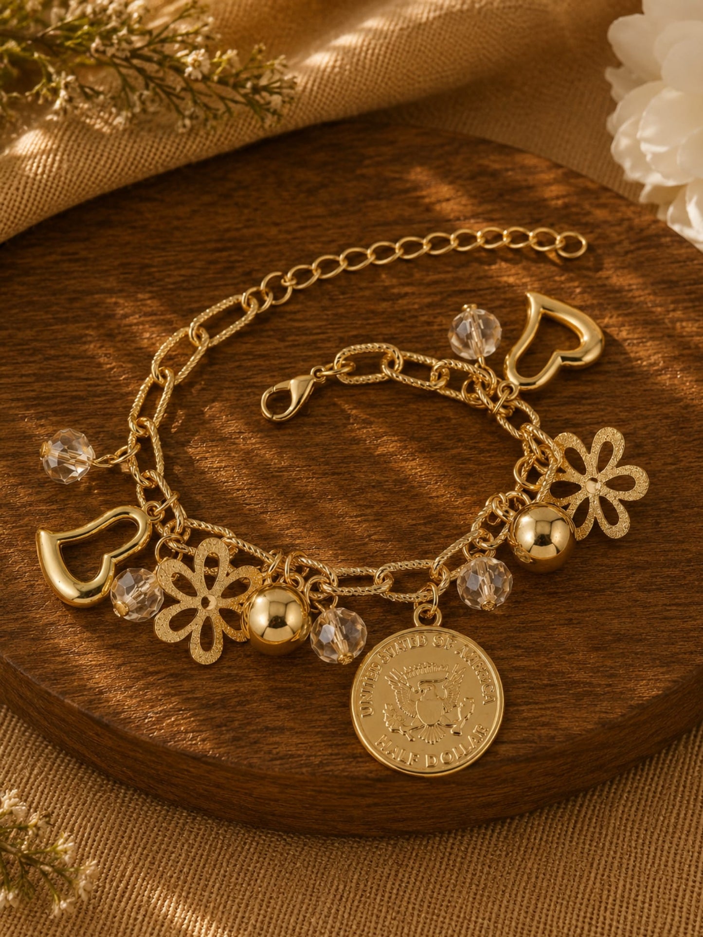 Multi charm beaded gold tone bracelet on an adjustable chain, laid flat
