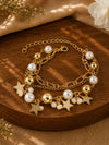 Multi charm gold tone beaded bracelet on an adjustable chain, laid flat