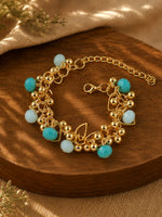 Gold tone chain beaded bracelet on an adjustable chain, laid flat