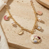 Floral multi-charm necklace on a chain, laid flat
