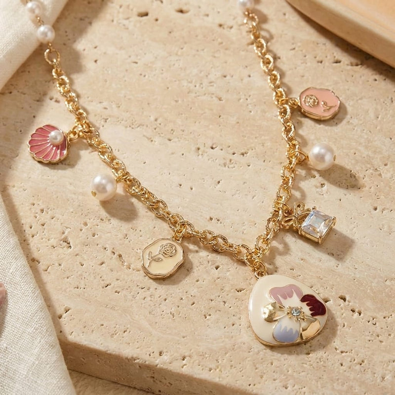 Floral multi-charm necklace on a chain, laid flat