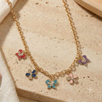 Diamond Stone butterfly and floral charm necklace on a chain, laid flat