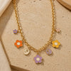 Floral multi-charm necklace on a chain, laid flat