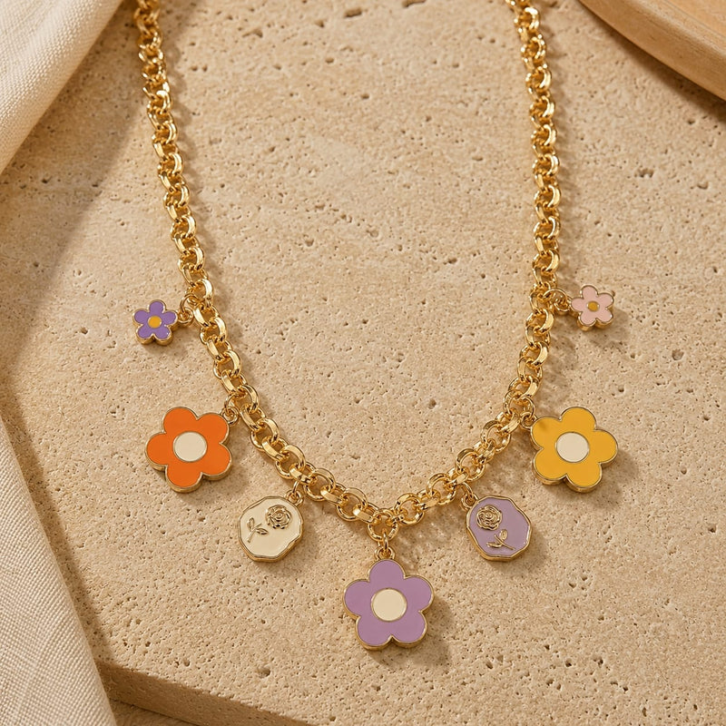 Floral multi-charm necklace on a chain, laid flat