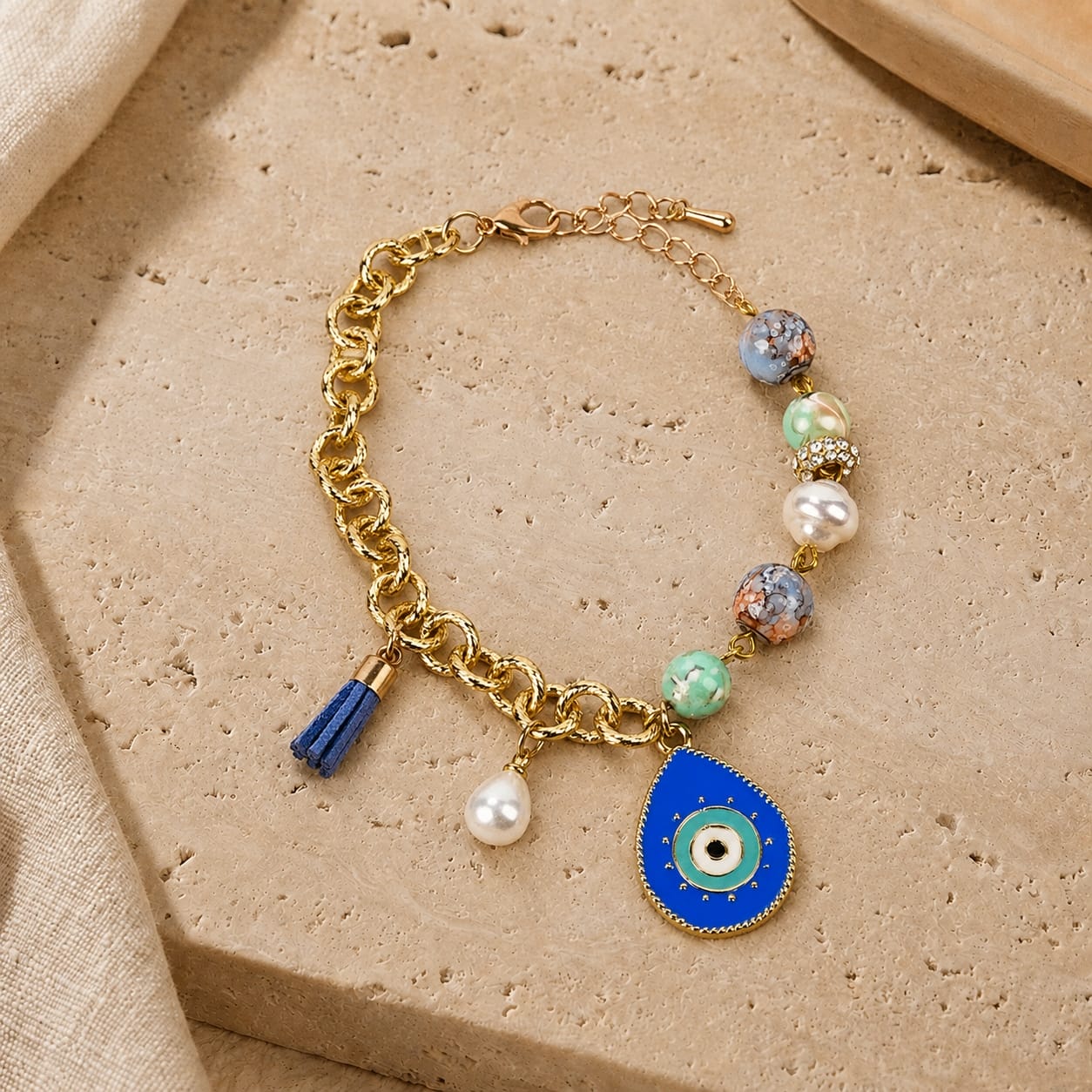 Gold chain Evil Eye charm bracelet with tassel, laid flat