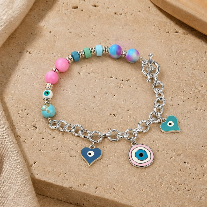 Silver-tone Evil Eye charm bracelet with pastel beads, laid flat