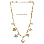 Gold chain necklace with dangling charms including flowers, stars, a crescent moon, and pearl-like beads, shown on a white background with text stating necklace length 22cms with extra loop.